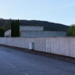Eduardo Souto de Moura’s Casa 2 no Bom Jesus showcasing a sloped concrete structure with composite material walls, tar roofing, and distinct shadow patterns.