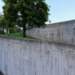 Eduardo Souto de Moura’s Casa 2 no Bom Jesus showcasing a minimalist concrete structure with composite material elements, pronounced shadows, and an elevated walkway.
