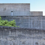 Eduardo Souto de Moura’s Casa 2 no Bom Jesus showcasing a minimalist concrete structure with grey composite walls and large daylighting elements.