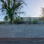 Eduardo Souto de Moura’s Casa 2 no Bom Jesus showcasing a minimalist design with composite material and concrete walls, brick accents, and an elevated walkway.