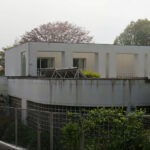Eduardo Souto de Moura’s Casa Rua da Índia showcasing a minimalist concrete exterior with a fenced yard and modern home fencing.