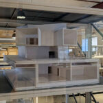 Eduardo Souto de Moura’s Casa do Cinema Manoel de Oliveira showcasing a modern interior with composite material walls, extensive glass panels allowing natural daylighting, and transparent structural elements emphasizing engineering and scientific design principles.
