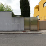 Eduardo Souto de Moura’s Casa na Senhora da Hora showcasing a minimalist concrete façade with plastered walls, home fencing, and a gated entrance in a suburban residential area.