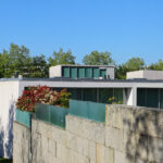 Eduardo Souto de Moura’s Casas Quinta da Avenida showcasing a concrete composite material wall with urban design elements, emphasizing daylighting and shadow effects.
