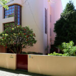 Eduardo Souto de Moura’s Duas Casas na Rua Beato Inácio de Azevedo showcasing daylighting through large windows, a balcony overlooking the street, and a hacienda-style architectural influence.