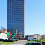 Eduardo Souto de Moura’s Edifício Burgo, a high-rise commercial building in a metropolitan urban area, featuring a sleek glass façade and modern structural design under daytime lighting.