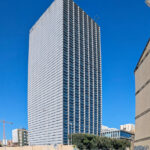Eduardo Souto de Moura’s Edifício Burgo, a high-rise commercial building in a metropolitan urban area, featuring a sleek blue glass façade and modern skyscraper design under daytime lighting.