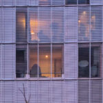 Eduardo Souto de Moura’s Edifício de Habitação Coletiva, a high-rise condominium with a symmetrical glass façade and metal composite materials reflecting the metropolitan area.