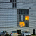 Eduardo Souto de Moura’s Edifício de Habitação Coletiva, a high-rise residential building featuring a composite material façade with extensive glass panels and daylighting elements.