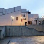 Eduardo Souto de Moura’s Fórum da Maia showcasing a brutalist concrete structure with monochrome composite materials and prominent exterior stairs integrated into the urban design.