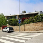 Eduardo Souto de Moura’s Habitações Unifamiliares showcasing a modern residential design with clean lines, concrete façades, and integration with urban elements including asphalt lanes, sidewalks, and zebra crossings.