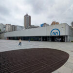 Eduardo Souto de Moura’s Metro do Porto station showcasing a concrete structure with composite material elements, featuring pedestrian walkways adjacent to a commercial corporate headquarters building.