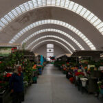 Fortunato Cabral and Cunha Leão’s Mercado de Matosinhos showcasing a commercial building with extensive daylighting, floral design elements, flowerpots, and a modern glass façade.