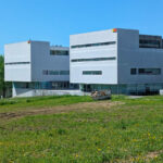 Gonçalo Byrne’s design of Escola de Engenharia II at Universidade do Minho showcasing a modern composite material façade with clean lines and an urban design integrating corporate headquarters elements.