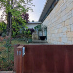House 1 to 6 designed by Jean Pierre Porcher, Joaquim Oliveira, and Albino Freitas featuring composite material walls, concrete and brick elements, shaded landscaping, and wood-stained finishes.