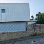 House 1 to 6 designed by Jean Pierre Porcher, Joaquim Oliveira, and Albino Freitas featuring grey concrete walls with composite materials and sloped cement surfaces.