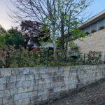 House 1 to 6 by Jean Pierre Porcher, Joaquim Oliveira, and Albino Freitas showcasing a modern design with stone and brickwork walls, concrete elements, and cobblestone pathways.