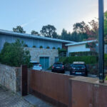 House 1 to 6 designed by Jean Pierre Porcher, Joaquim Oliveira, and Albino Freitas featuring concrete walls with composite materials, sloped driveways, shaded landscaping with conifers, and ample daylighting.