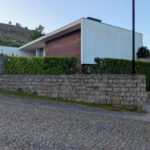 Loteamento D. Antónia Amorim by Jean Pierre Porcher, Margarida Oliveir, and Albino Freitas showcasing a concrete slope with a driveway integrated into the terrain.