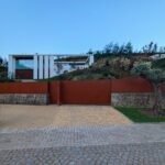 Loteamento D. Antónia Amorim by Jean Pierre Porcher, Margarida Oliveir, and Albino Freitas showcasing landscaped gardens and traditional hacienda-style architecture with terracotta roofs and lush greenery.
