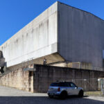 Jorge Nuno Monteiro’s Pavilhão Desportivo Municipal de Santo Tirso showcasing a brutalist concrete structure with composite materials, prominent stairs, and urban design elements.