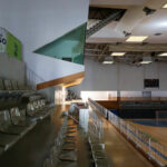 Jorge Nuno Monteiro’s Pavilhão Desportivo Municipal de Santo Tirso showcasing a spacious sports hall with hardwood wood flooring, wooden ceiling panels, and ample daylighting through large windows.