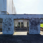 Jorge Nuno Monteiro’s Pavilhão Desportivo Municipal de Santo Tirso showcasing a brutalist concrete structure with grey composite materials, prominent walls, and engineered daylighting elements.