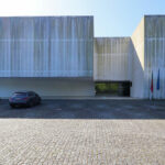 Manuel Aires Mateus’s Call Centre Santo Tirso showcasing brutalist architecture with exposed concrete surfaces and large windows designed for optimal daylighting.