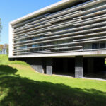 OPERA | Design Matters' Escola de Medicina, Universidade do Minho, showcasing a composite material façade with integrated shading elements and dynamic daylighting creating distinct shadows on the headquarters building.