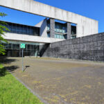 OPERA | Design Matters' Escola de Medicina, Universidade do Minho, showcasing a brutalist concrete structure with extensive daylighting, walkways, and community center elements on a university campus.