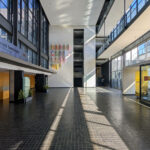 OPERA | Design Matters' Escola de Medicina, Universidade do Minho, showcasing a modern commercial building with a glass and aluminium façade, composite materials, and engineered daylighting features in a metropolitan area.