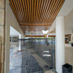 Ricardo Vieira de Melo and Eduardo Rebelo’s Complexo Pedagógico II at Universidade do Minho showcasing a modern design with extensive use of wood planks, composite materials, metal accents, hardwood finishes, and large glass panels allowing ample daylighting.