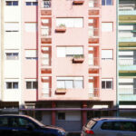 Colorful buildings of Rua António José da Costa designed by Unknown Architect featuring vibrant painted facades, balconies with glass railings, and composite materials in a high-rise urban condominium setting emphasizing daylighting.