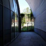 Unknown Architect’s Serviços de Ação Social at Universidade do Minho showcasing a steel-framed structure with metal shading elements and engineered daylighting features casting dynamic shadows.
