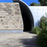 Unknown Architect’s Serviços de Ação Social at Universidade do Minho showcasing a concrete composite structure with shaded walkways and dynamic daylighting creating distinct shadows.