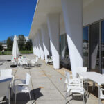 Unknown Architect’s Complexo Pedagógico III at Universidade do Minho showcasing composite material columns, shaded ceiling design, daylighting, and modern chairs in a restaurant setting.