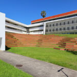 Unknown Architect’s Escola de Economia e Gestão at Universidade do Minho showcasing a modern campus building with a lawn, exterior stairs, and clean geometric lines.