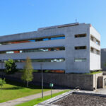 Unknown Architect’s Escola de Engenharia I at Universidade do Minho showcasing a concrete corporate headquarters with composite material elements and an elevated walkway integrated into urban design.