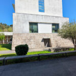 Unknown Architect’s Escola de Engenharia I at Universidade do Minho showcasing a concrete and composite material façade with clean lines, urban design elements, and a surrounding lawn under daytime lighting.