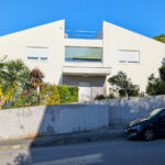 Unknown Architect’s Villa 3 Rua Pinho Leal showcasing a modern residential home with concrete construction, a shaded driveway, and a spacious land lot in a suburban estate.