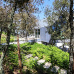 Unknown Architect’s Villa Brufe showcasing a modern home nestled on a slope with extensive vegetation surrounding the structure.