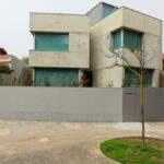 Unknown Architect’s Villa I Praça de Liége showcasing a modern residential home with concrete construction, composite materials, balconies, and urban design elements emphasizing daylighting in a suburban setting.