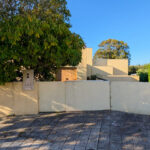 Unknown Architect’s Villa I Rua Júlio Dantas showcasing a modern concrete structure with composite material walls, shaded landscaping, home fencing, and sunlight casting shadows during daytime.