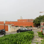 Unknown Architect’s Villa Rua do Farol showcasing a modern residential design with clean wall surfaces, a tar driveway, street lighting, and a parked subcompact car in a suburban setting.
