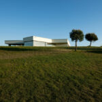Nuno Brandao Costa’s 7 Houses in Óbidos at Bom Sucesso Resort showcasing minimalist structures with flat roofs and clean lines set against a plain land lot with shadows and open steppe hinterland.