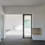 Nuno Graça Moura’s 13 Villas at Bom Sucesso Resort showcasing concrete walls, composite material flooring, plaster finishes, tile flooring, and large home doors with ample daylighting.