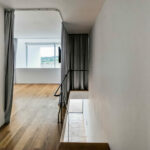 Nuno Graça Moura’s 24 Row Houses at Bom Sucesso Resort showcasing wood plank flooring with composite and hardwood materials, featuring natural daylighting and grey plywood elements.
