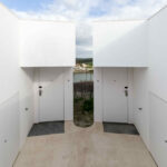 Nuno Graça Moura’s 24 Row Houses at Bom Sucesso Resort showcasing a series of concrete and composite material structures with plaster finishes and strategic daylighting elements.