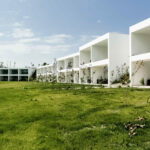 Nuno Graça Moura’s 24 Row Houses at Bom Sucesso Resort showcasing modern villas with landscaped courtyards, green lawns, and integrated hotel-style architecture.