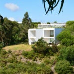 Nuno Graça Moura’s 24 Row Houses at Bom Sucesso Resort showcasing modern estate architecture with linear row house structures surrounded by chaparral vegetation and shrubs.